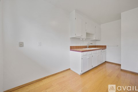 A kitchen with white cabinets and a wooden countertop.