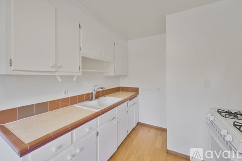A kitchen with white cabinets and a tiled backsplash.