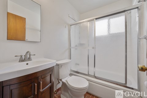 A bathroom with a toilet, sink, and shower.