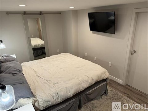 A bedroom with a bed, a television, and a sliding door.