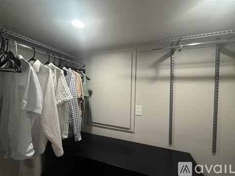 Clothes hanging on a rack in a room.