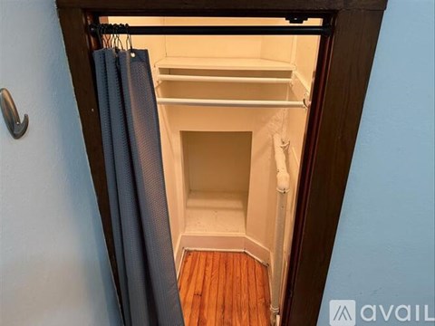 A small, empty pantry with a white door and a white shelf.
