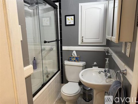 A bathroom with a toilet, sink, and shower.