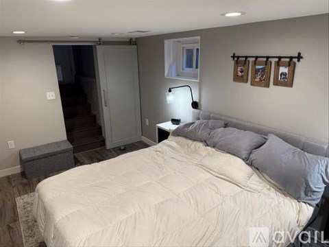 A bedroom with a bed, nightstand, and a lamp.