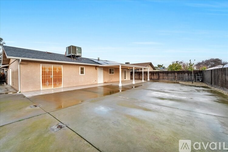 A large, empty house with a concrete driveway is available for rent.