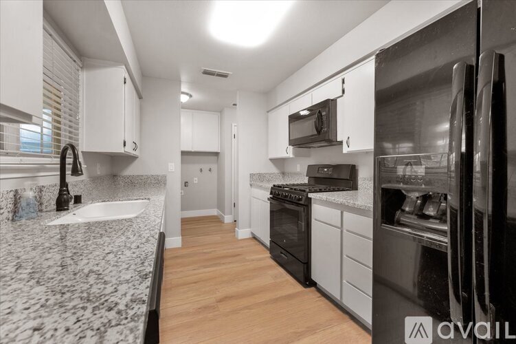A kitchen with a granite countertop and stainless steel appliances.