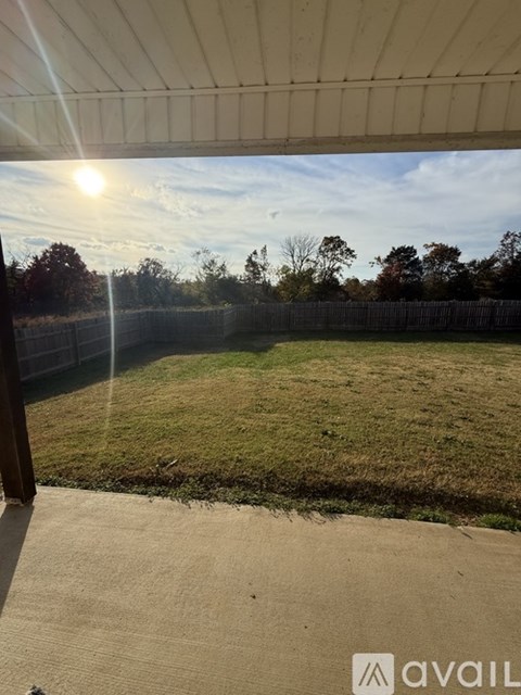 A backyard with a fence and a grassy area.