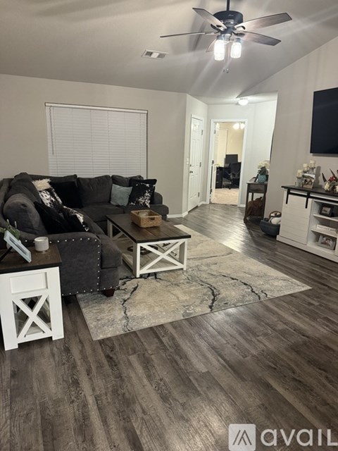 A living room with a black couch and a white coffee table.