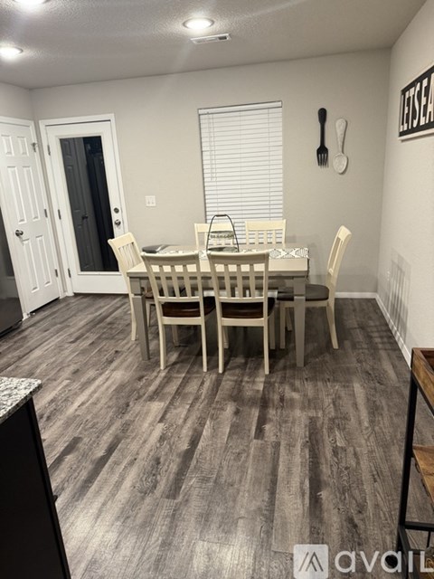 A dining room with a wooden table and chairs.