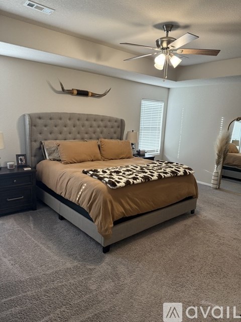 A bedroom with a large bed and a ceiling fan.