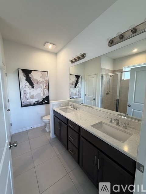 A bathroom with a white sink and a large mirror.