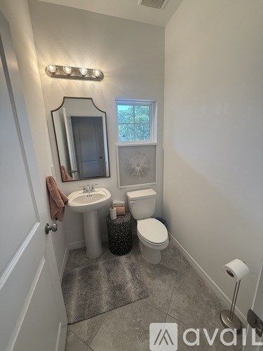 A bathroom with a sink, toilet, and mirror.