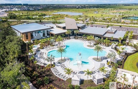 A large resort with a pool and palm trees.