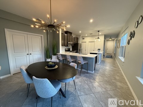 A dining room with a round table and chairs.
