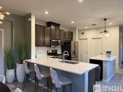 A modern kitchen with a large island and white countertops.