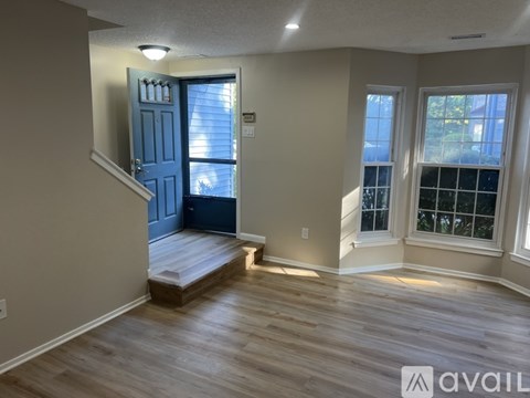 A room with a blue door and wooden flooring.