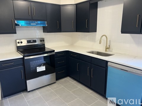 A kitchen with black cabinets and a stainless steel oven.