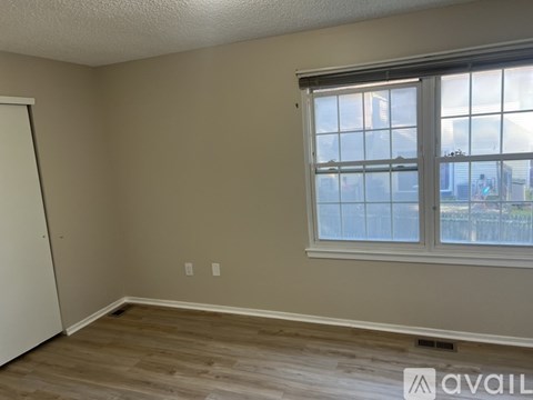 A room with a window and wooden flooring is available for rent.