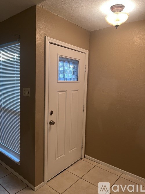 A white door with a window above it in a room.