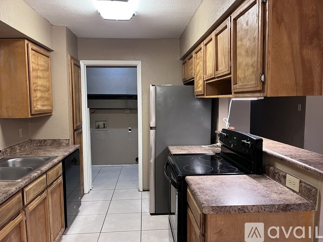 A kitchen with wooden cabinets and a black stove top oven.