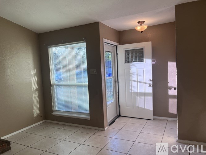 A room with a white door and a window with blinds.
