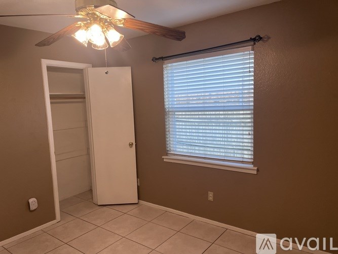 A room with a white door and a ceiling fan.