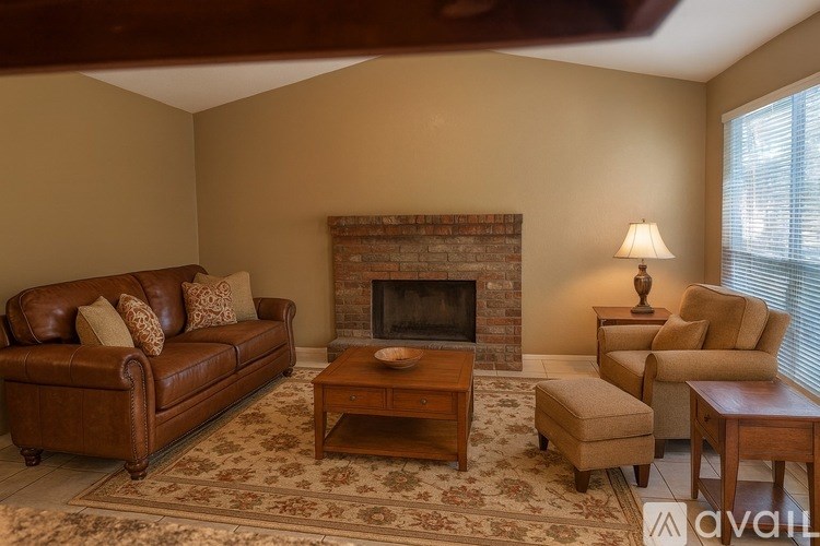 A living room with a fireplace and a brown couch.