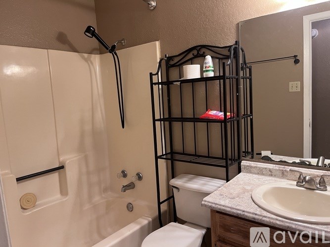 A bathroom with a white tub, toilet, and sink.