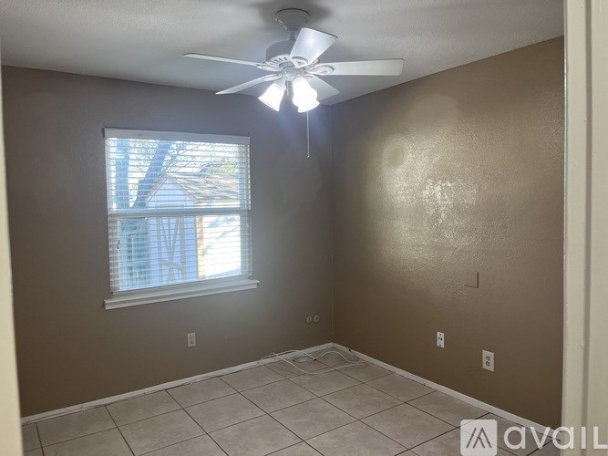 A room with a ceiling fan and a window.