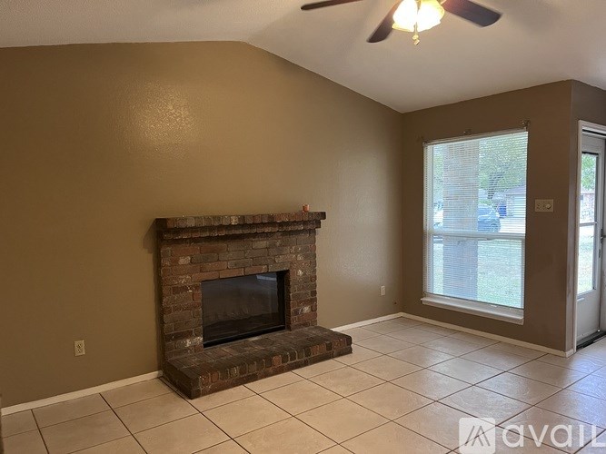 A living room with a fireplace and a ceiling fan.