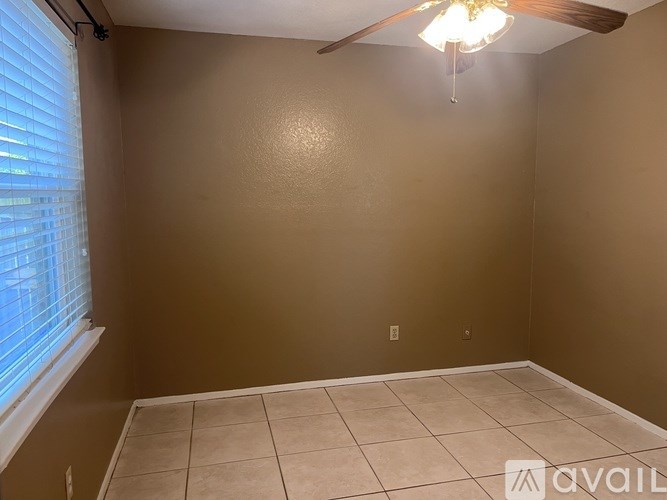 A room with beige walls and a ceiling fan with lights.