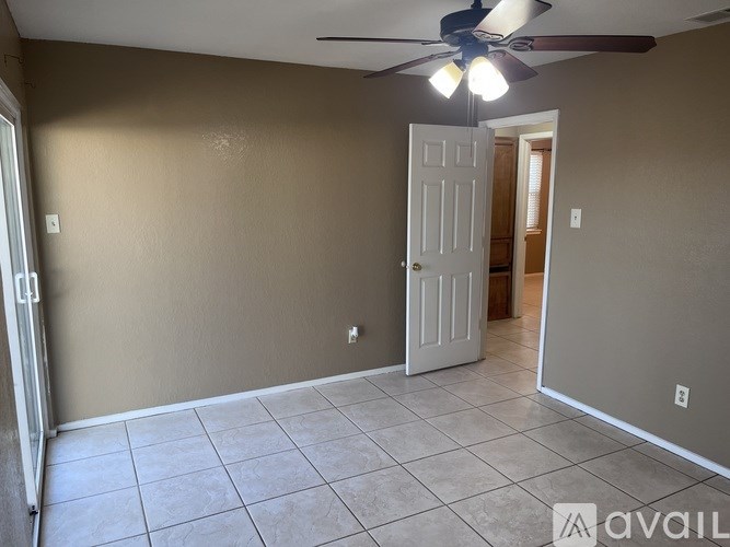 A room with a ceiling fan and tile flooring.