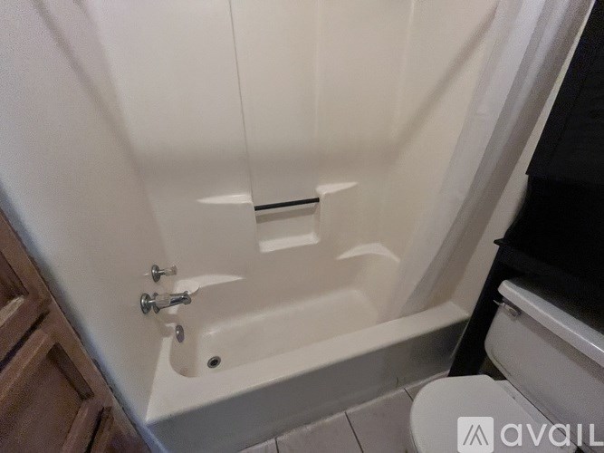 A white bathtub with a silver faucet and a silver handle.