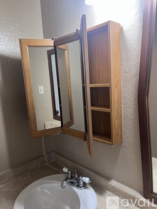 A bathroom with a sink, mirror and medicine cabinet.
