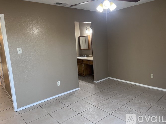 A room with a tiled floor and a mirror on the wall.