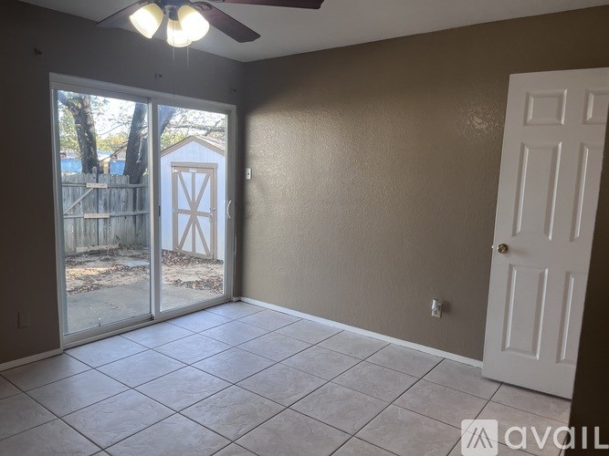 A room with a sliding glass door leading to a backyard.