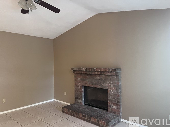 A room with a fireplace and a ceiling fan.