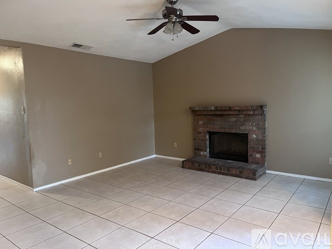 A room with a fireplace and a ceiling fan.