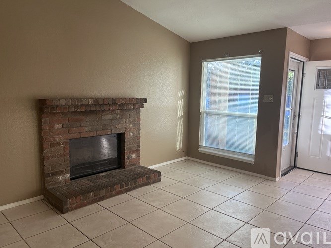 A room with a fireplace and a door leading to another room.