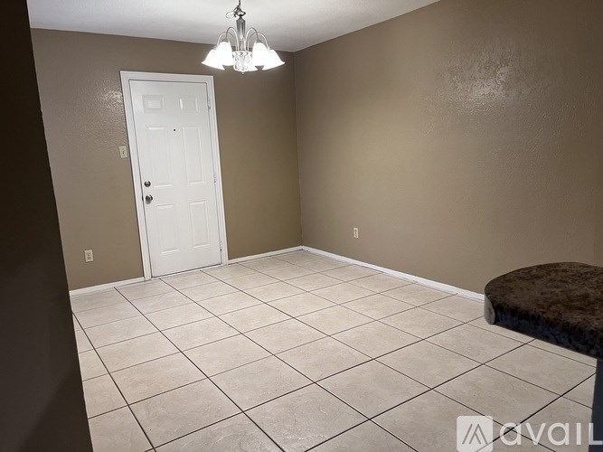 A room with a white door and a brown bench.