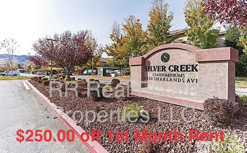 A sign for Shaver Creek Condominiums is displayed in front of a parking lot.
