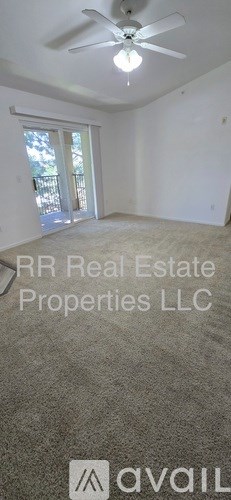 A room with a ceiling fan and a window with blinds.