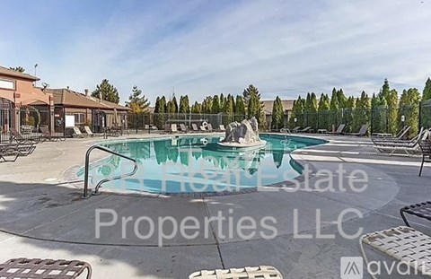 A large swimming pool with a slide and a fence around it.