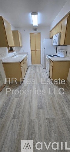 A kitchen with wooden cabinets and a white fridge.