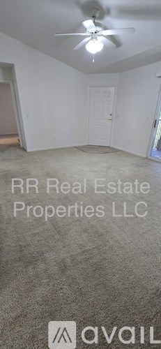 A room with a ceiling fan and a door.