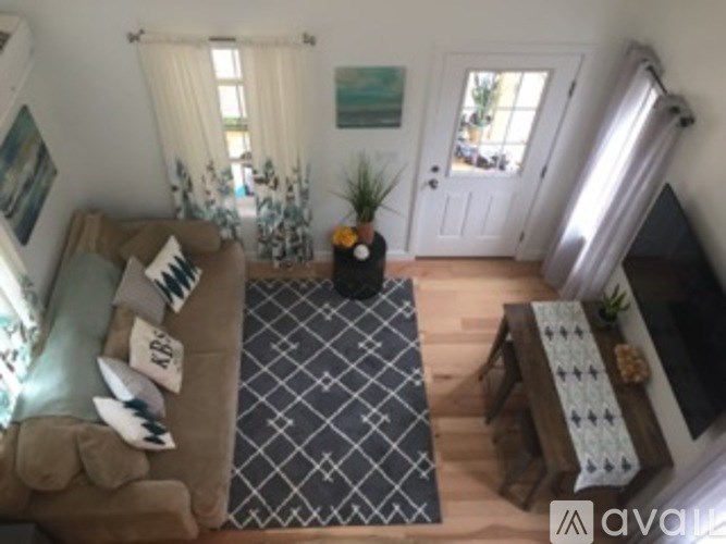 A living room with a couch, a rug, and a television.