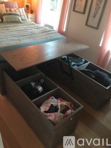 A bedroom with a bed and a dresser with drawers.