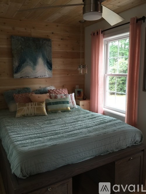 A bedroom with a bed and a painting on the wall.
