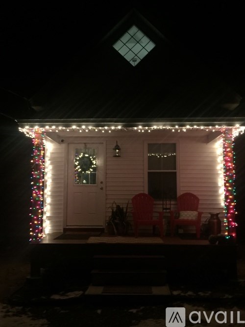 A house is decorated with Christmas lights and has a wreath on the door.