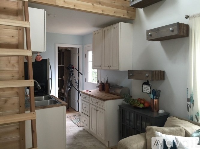 A kitchen with wooden cabinets and a black refrigerator.